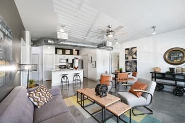Dallas apartment for rent - a living room with couches and chairs and a kitchen in the background