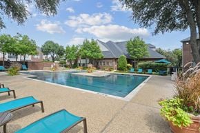 Dallas apartment for rent - A pool surrounded by lounge chairs and trees.