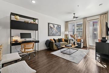 Plano apartment for rent - A modern living room with a black sofa and a wooden desk.