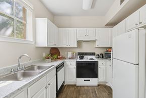 San Antonio apartment for rent - A kitchen with white cabinets and appliances.