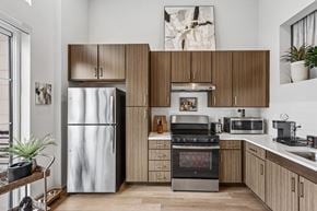 Huntsville apartment for rent - A modern kitchen with a stainless steel refrigerator and wooden cabinets.