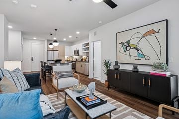 Frisco apartment for rent - A living room with a large painting on the wall and a coffee table in the center.