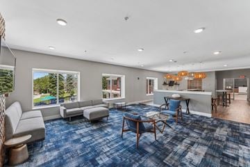 Eden Prairie apartment for rent - A spacious living room with a blue carpet and furniture.