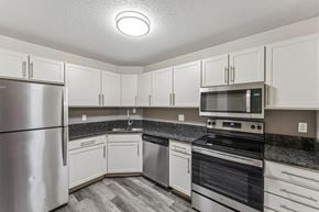 Eden Prairie apartment for rent - A kitchen with white cabinets and a stainless steel refrigerator.