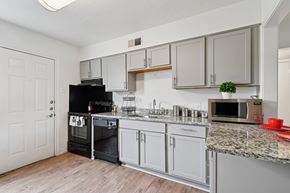 Dallas apartment for rent - A kitchen with a black oven and white cabinets.