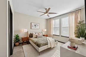 Huntsville apartment for rent - A bedroom with a bed, nightstand, and a ceiling fan.