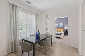Durham apartment for rent - A dining room with a table and chairs and a view of a bedroom through the window.