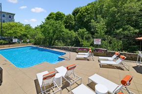 North Smithfield apartment for rent - A pool surrounded by trees and chairs.