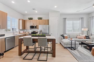 Colorado Springs apartment for rent - A modern kitchen with a dining table and a living room area.