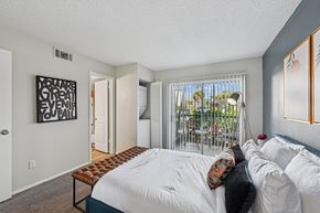 Palm Bay apartment for rent - A bedroom with a large bed and a window with a view of the outside.