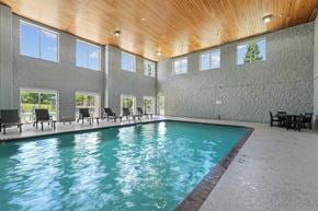 Eden Prairie apartment for rent - A large indoor swimming pool with a wooden ceiling and multiple windows.