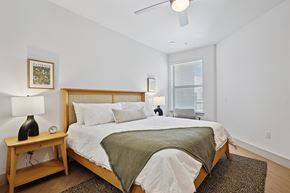 Carrollton apartment for rent - A bedroom with a bed, nightstand, and window.