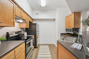 Raleigh apartment for rent - A kitchen with wooden cabinets and black appliances.
