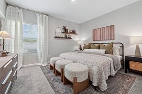 Jacksonville apartment for rent - A bedroom with a large bed, a window with curtains, and a wooden dresser.