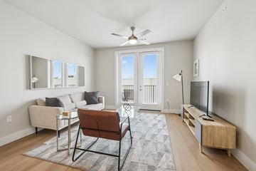 Dallas apartment for rent - A living room with a brown chair and a glass table.