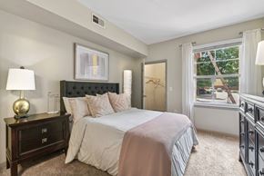 San Antonio apartment for rent - A bedroom with a large bed and a nightstand with a lamp.