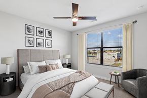 Spring apartment for rent - A bedroom with a large bed and a ceiling fan.