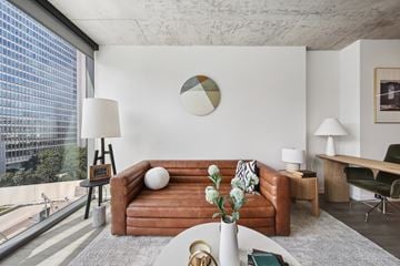Chicago apartment for rent - A living room with a brown couch and a round decoration on the wall.