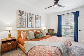 Lewisville apartment for rent - A bedroom with a large bed and a ceiling fan.