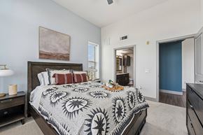 Carrollton apartment for rent - A bedroom with a large bed and a painting on the wall.