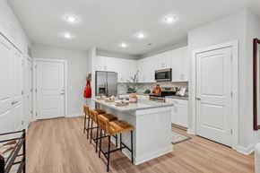 Suwanee apartment for rent - A kitchen with white cabinets and a wooden floor.
