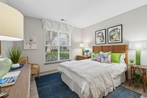 Winston Salem apartment for rent - A bedroom with a large bed and a window with blinds.