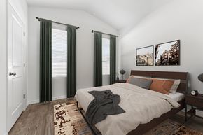 Gainesville apartment for rent - A bedroom with a bed, two pictures on the wall, and a rug on the floor.