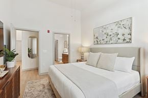 Huntsville apartment for rent - A bedroom with a large bed and a painting on the wall.