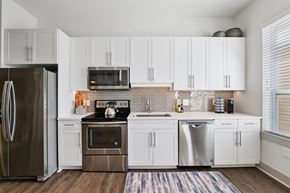 Charlotte apartment for rent - A modern kitchen with white cabinets and stainless steel appliances.