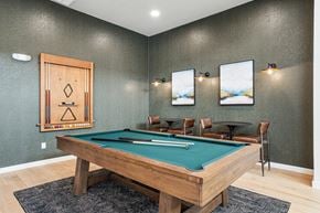 Sherman apartment for rent - A pool table is in the middle of a room with a wooden cabinet and two chairs.