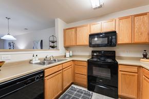 Raleigh apartment for rent - A kitchen with black appliances and wooden cabinets.