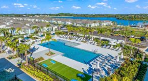 Sarasota apartment for rent - A large swimming pool surrounded by lounge chairs and umbrellas is the focal point of a resort-like setting.
