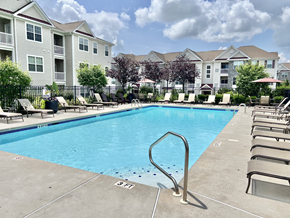 South Amboy apartment for rent - Dog-Friendly Garden-Style Apartments in Sayreville, NJ- Morgan's Bluff - A Swimming Pool with Lounge Chairs, and Apartment Building View.