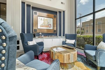 Dallas apartment for rent - A living room with blue chairs and a wooden coffee table.