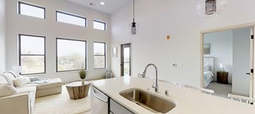 Monona apartment for rent - A modern kitchen with a large island and a living room area with a sofa and a coffee table.