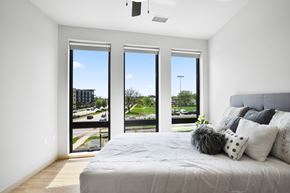 Madison apartment for rent - A bedroom with a large bed and a view of the outside through the windows.