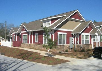 Hinesville apartment for rent - A red house with a white trim and a brown roof.