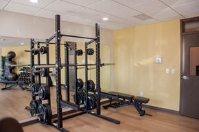 Fargo apartment for rent - A gym with a squat rack and weights.