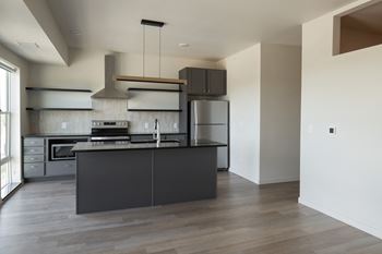 A kitchen with a black island and stainless steel appliances 