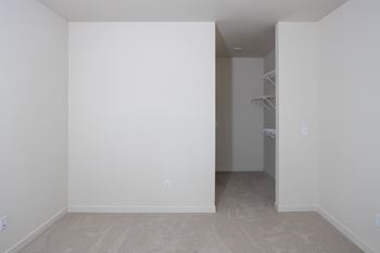 An empty room with white walls and a closet 