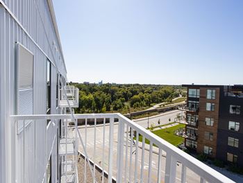 A balcony with a view of a park and some buildings 