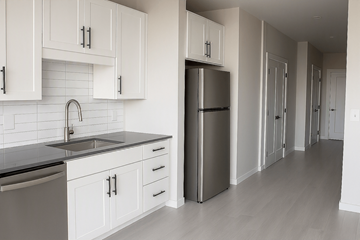 Fargo apartment for rent - A kitchen with white cabinets and a black counter top.