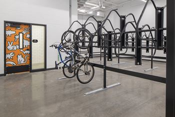 A bike rack with several bikes on it and a door with a mural on it