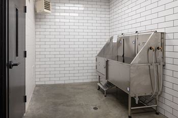 A large metal tub in a white tiled room