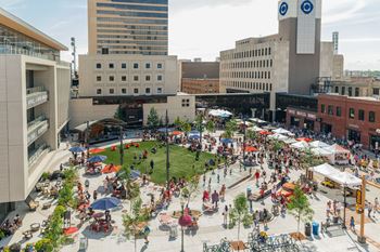 A large open plaza with people sitting and walking around