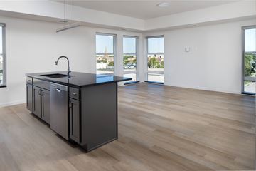 Fargo apartment for rent - an open kitchen and living room with a large window and a black counter top