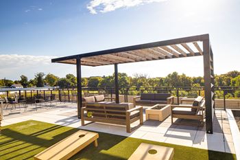A rooftop patio with lounge furniture and a pergola 