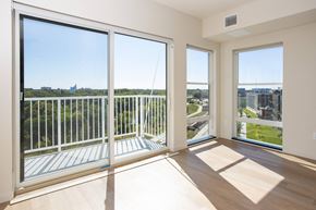 Fargo apartment for rent - a living room with large windows and a view of the city at Riverhouse Apartments, Fargo, ND