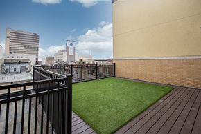Fargo apartment for rent - a small astroturf lawn on a balcony with a city in the background at RoCo Apartments, Fargo, ND 58102