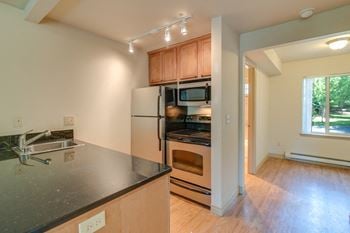 Open kitchen with refrigerator, microwave, oven, stove, and sink